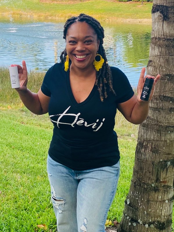 our founder wearing our branded Klevij v-neck t-shirt and holding breast deodorant products